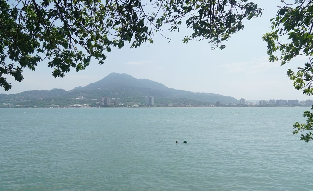 安克黑咖啡 綠葉框景下的觀音山與寬闊淡水河面實拍